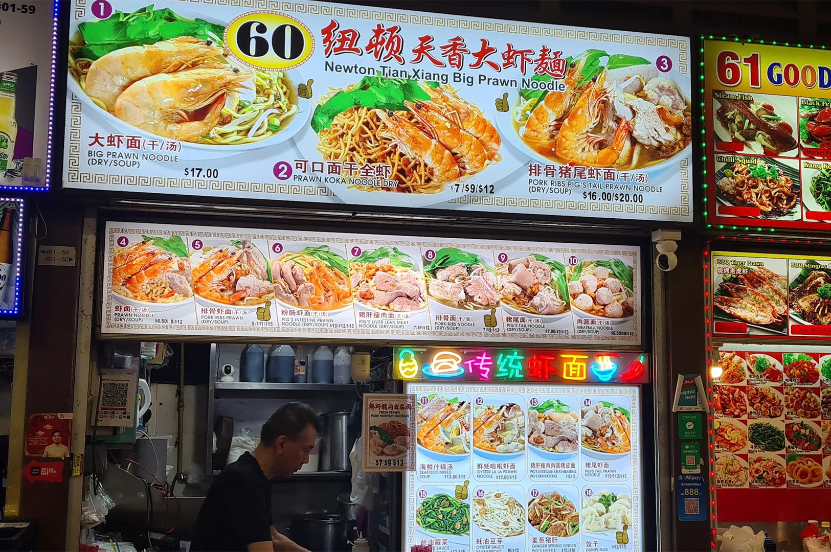 Illuminated menu board of Newton Tian Xiang Big Prawn Noodle (Stall 60), showing various prawn and pork rib noodle dishes.