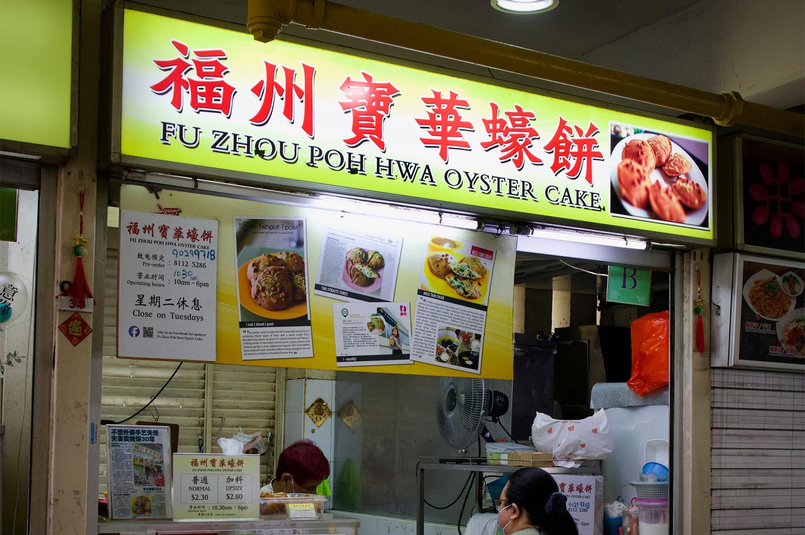 The storefront of Fu Zhou Poh Hwa Oyster Cake stall at a Singapore hawker center with menu and operating hours.