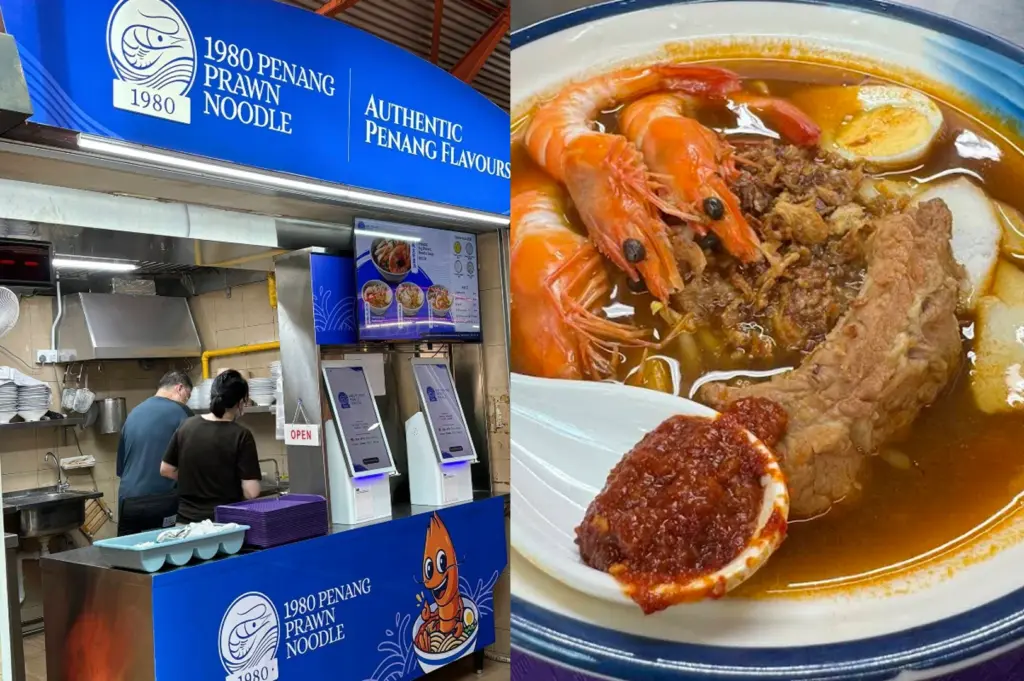 A split-screen image showcasing a modern hawker stall and a bowl of soup. The left side shows the "1980 Penang Prawn Noodle" stall, characterized by a clean, vibrant blue and white theme. Two staff members in dark t-shirts are working in the background of the small kitchen. Two white self-service ordering kiosks stand at the front counter. The right side is a top-down close-up of a bowl of Penang prawn noodles. The dish consists of thick yellow noodles in a rich, dark orange broth, topped with several large whole prawns, slices of pork rib, half a hard-boiled egg, and a sprinkle of fried shallots. A white ceramic spoon rests on the side, holding a generous portion of thick red sambal chili.