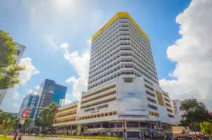 A high-angle view of the bustling Fortune Centre in Singapore, showcasing its retro architecture and numerous vegetarian eateries and local shops that define this iconic community hub in the Middle Road area.