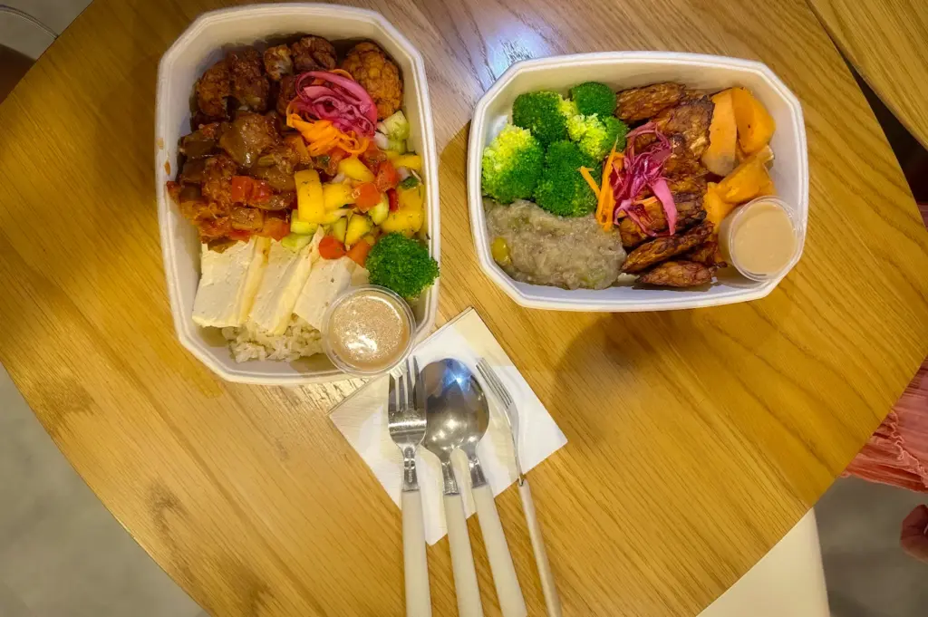 A colorful and healthy vegetarian grain bowl from EN Seeds in Fortune Centre, Singapore, packed with fresh ingredients including broccoli, purple cabbage, seasoned mushrooms, corn, and cherry tomatoes over a base of wholesome grains.