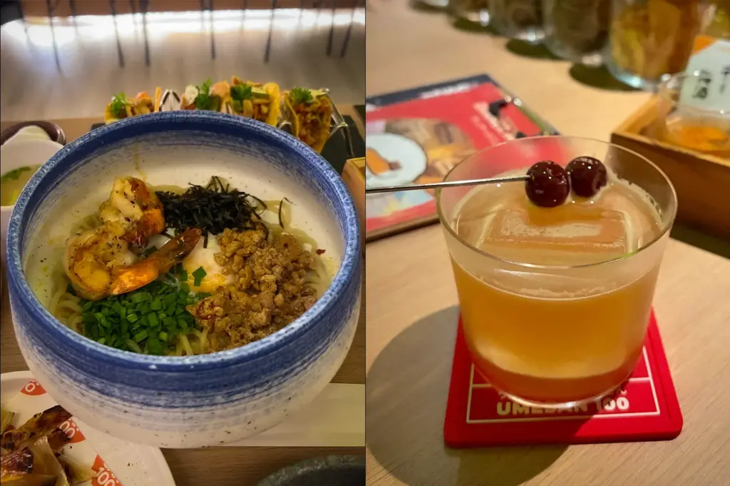 Side-by-side photo of a Japanese noodle bowl with shrimp and minced meat beside a whiskey-style cocktail with cherries served at UME SAN 100 in Singapore