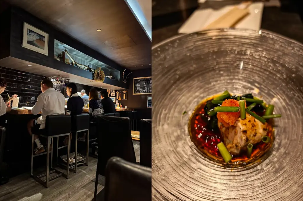 This split-composition image features two distinct views of a sophisticated dining experience. On the left, a wide-angle shot shows several patrons seated on high black barstools along a long, live-edge wooden counter in a dimly lit, modern Japanese restaurant. The bar is set against a backdrop of glossy black subway tiles and minimalist decor, with soft warm lighting and a recessed shelf displaying traditional artifacts. On the right, a top-down close-up captures an artfully plated dish served in a textured, clear glass bowl with concentric circular ridges. The dish features a delicate piece of cooked fish or protein resting in a vibrant reddish-brown sauce, garnished with bright green stalks, dark seaweed, and a dollop of orange citrus-based condiment, highlighting a refined and contemporary culinary style.