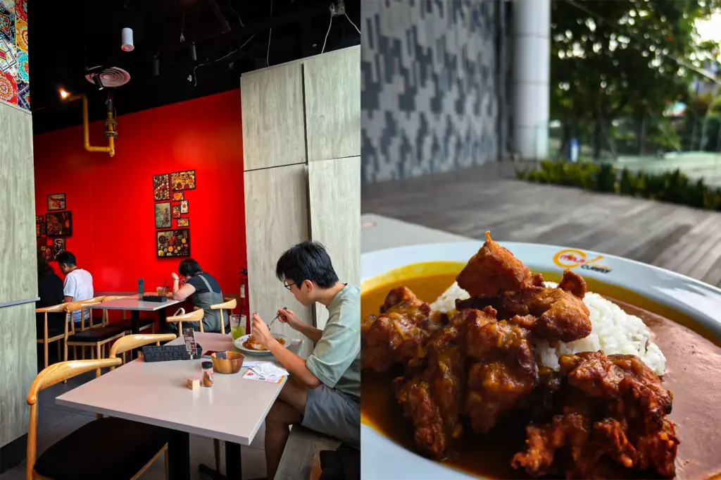 This split-composition image depicts the interior and a signature dish of a dining establishment, representing the file "5-From Hidden Counters to Iconic Eateries 5 Best Japanese Curry.webp". On the left side, an eye-level shot shows customers dining in a modern restaurant featuring light-colored tables, wooden chairs with black seats, and a striking, bright red accent wall decorated with small framed artwork. On the right side, a close-up, high-angle shot highlights a plate of Japanese curry served on a white rimmed dish, featuring a mound of white rice partially covered by a smooth, golden-brown curry sauce and topped with a generous portion of crispy, deeply fried karaage or chicken chunks. The plate is positioned on an outdoor-facing counter or table, with a blurred background showing a grey patterned wall, a wooden deck, and green trees.